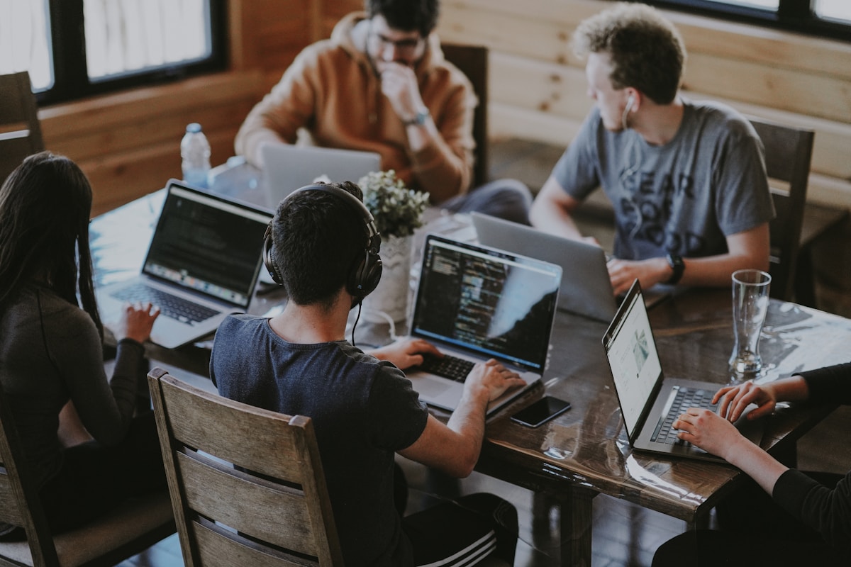 Jóvenes ingenieros analizando código en portátiles